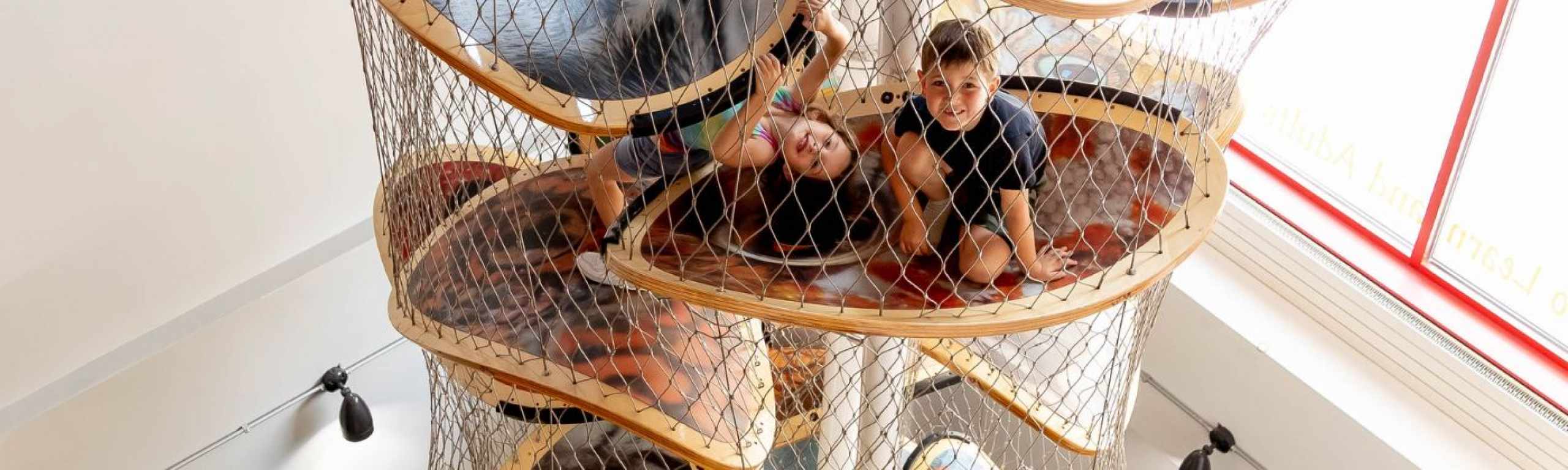 A young boy and girl play on the cleary luckey climber